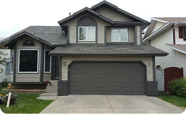 Light brown house with dark brown trim and garage door