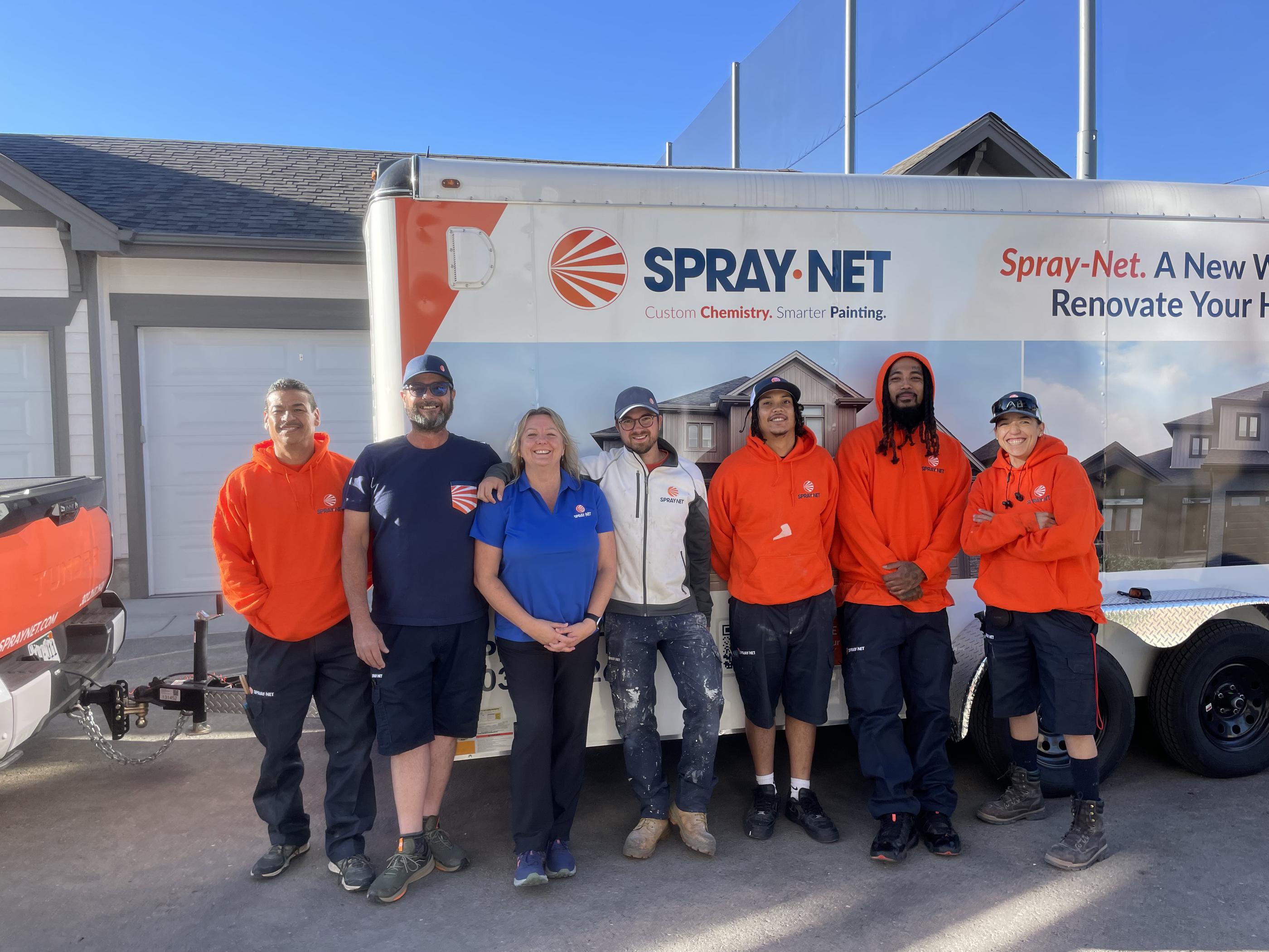 Spray-Net team standing together in front of a company truck.