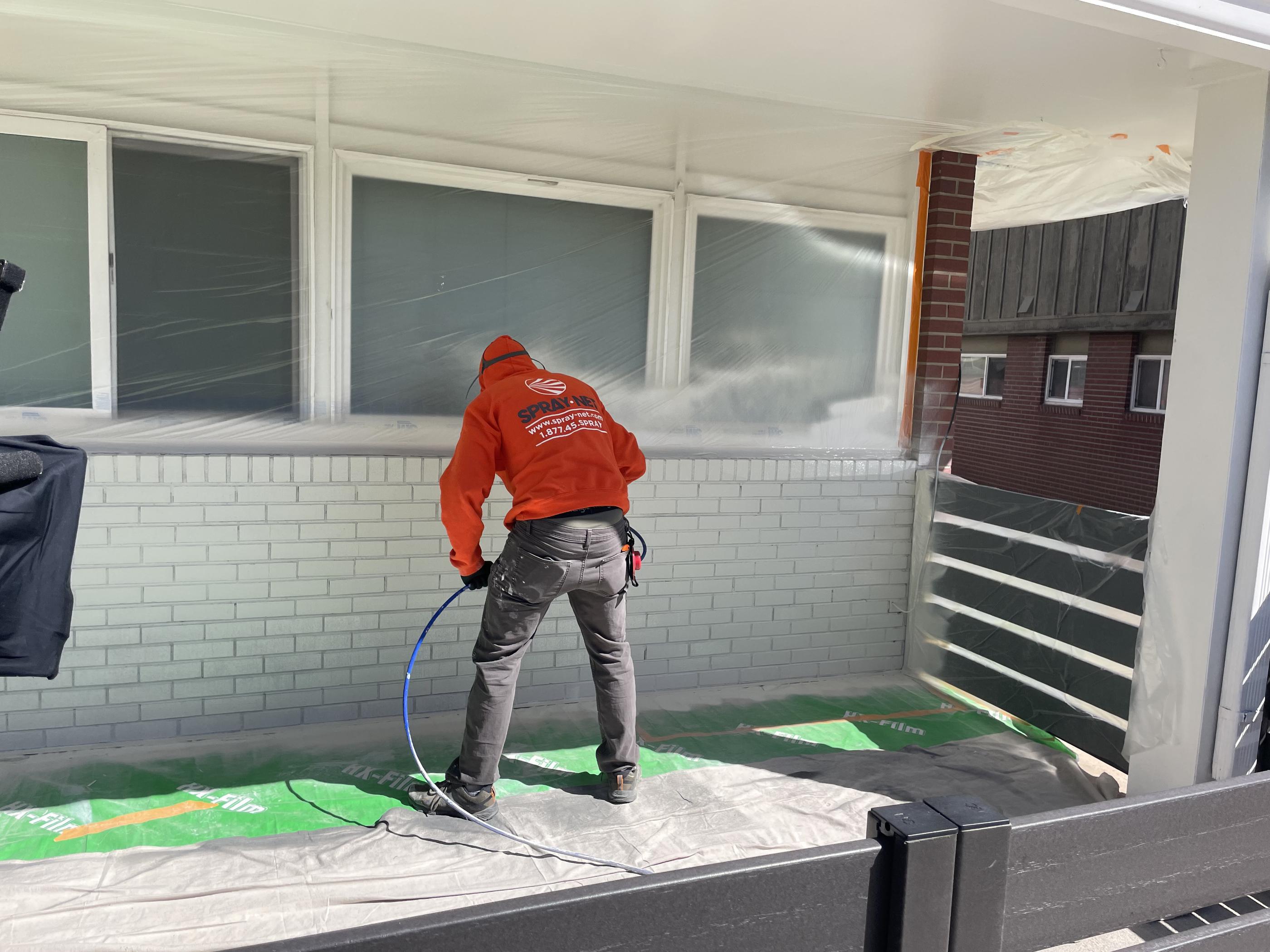 Spraynet employee working on a house