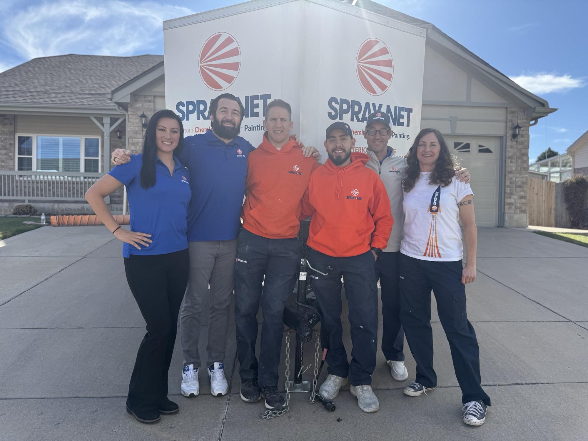 Spray-Net team standing together in front of a company truck.