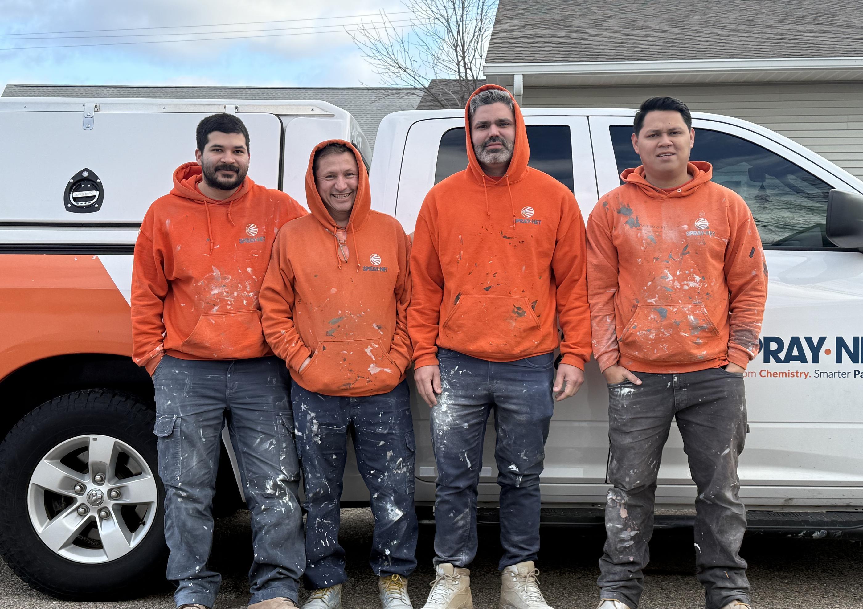 Spray-Net team standing together in front of a company truck.
